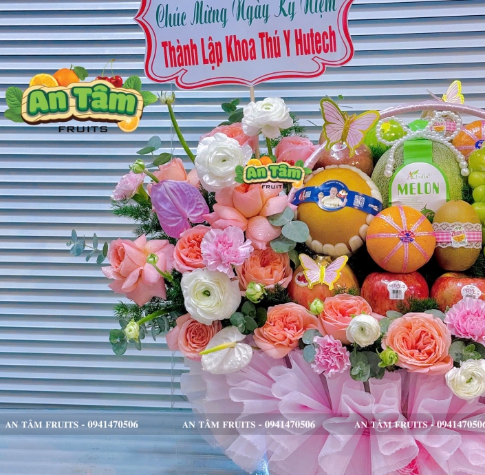 Giỏ trái cây phối hoa hai bên tone hồng chúc mừng kỷ niệm