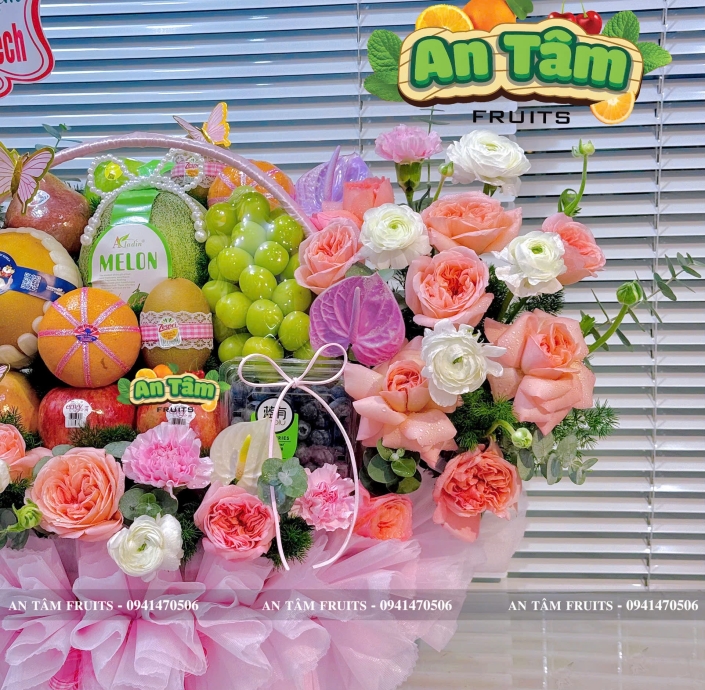 Giỏ trái cây phối hoa hai bên tone hồng chúc mừng kỷ niệm